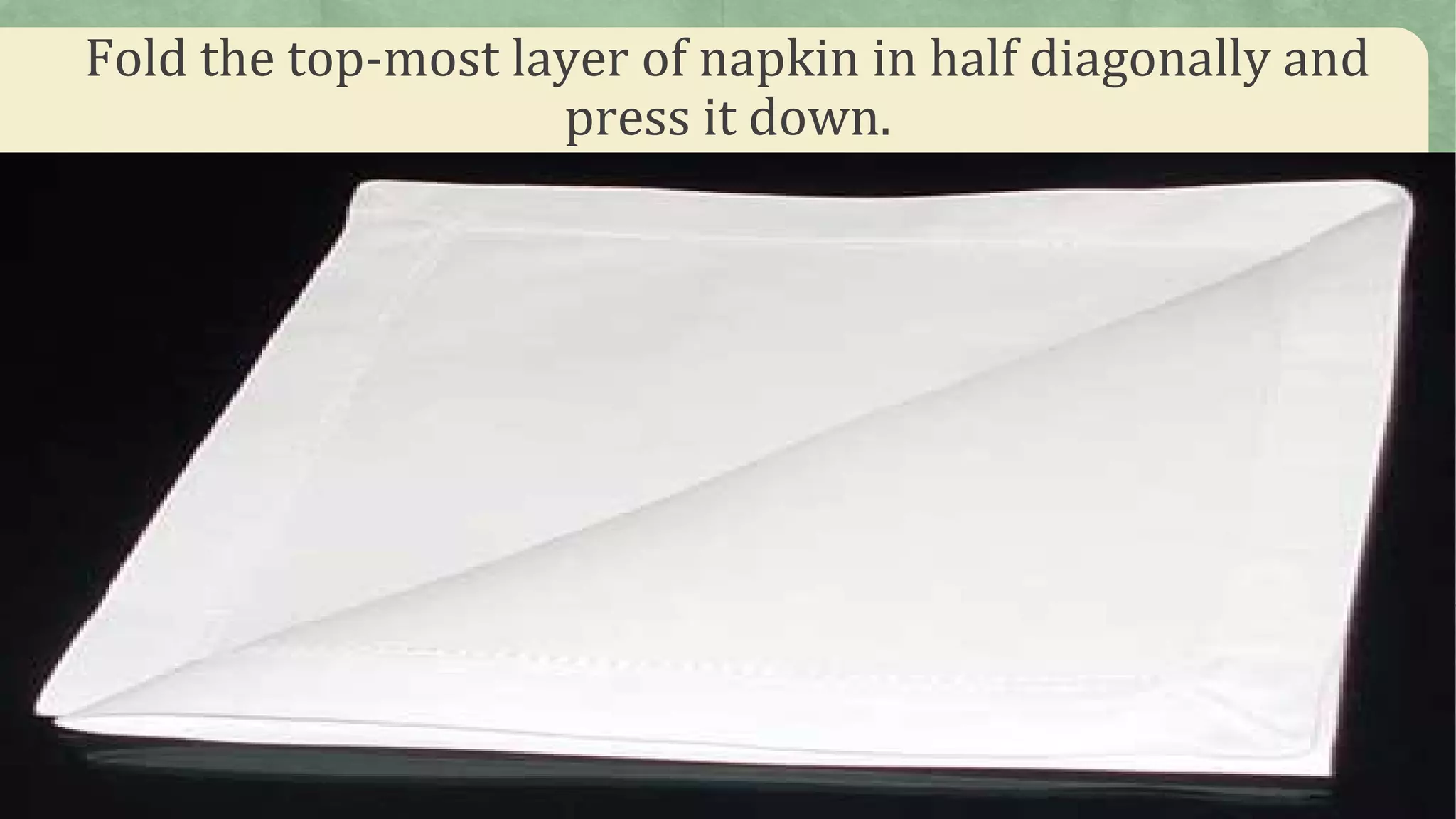 Fold the top-most layer of napkin in half diagonally and
press it down.
 