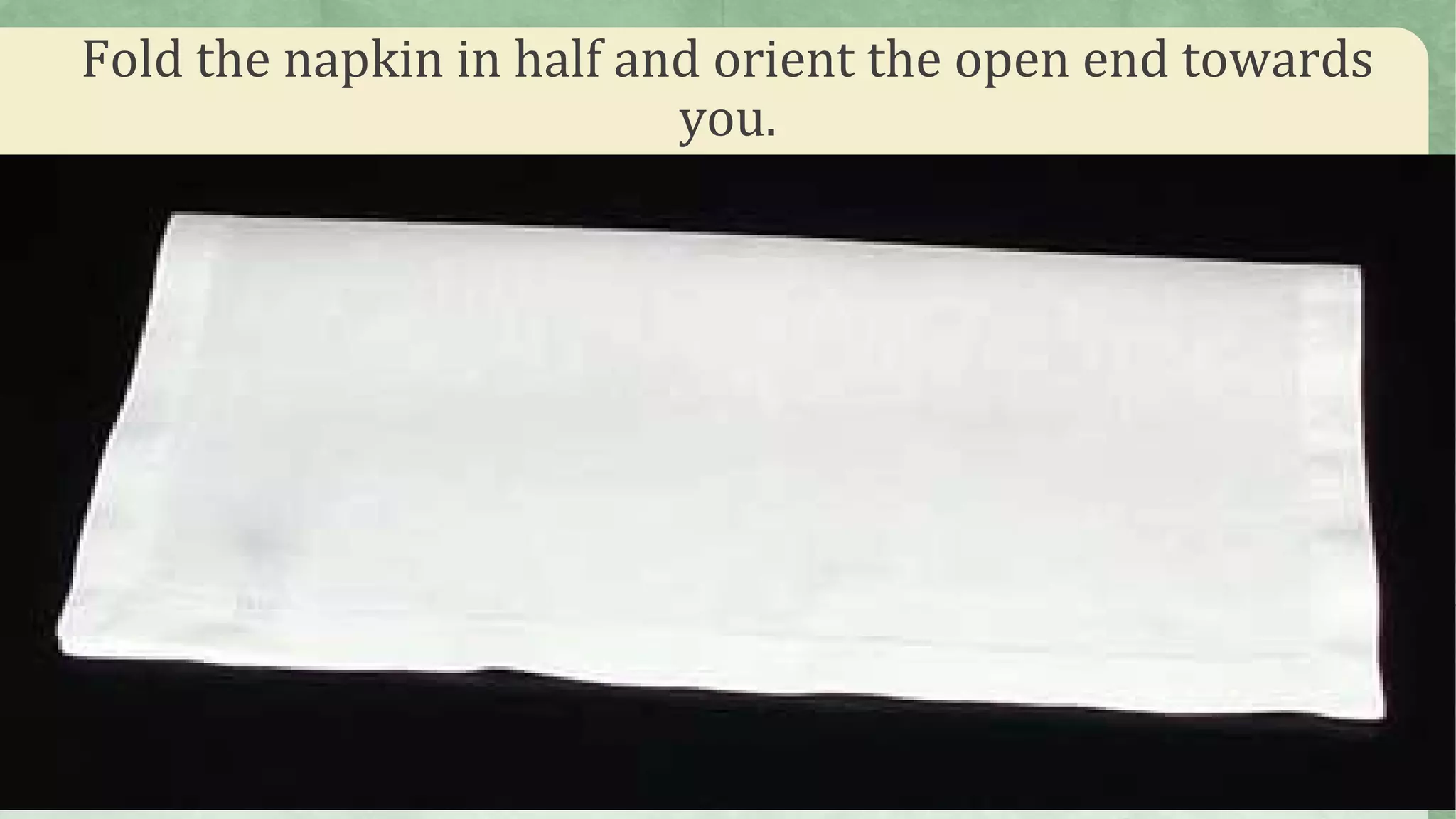 Fold the napkin in half and orient the open end towards
you.
 