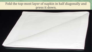 Fold the top-most layer of napkin in half diagonally and
press it down.
 