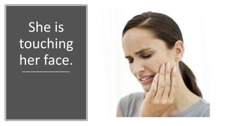 She is
touching
her face.
 