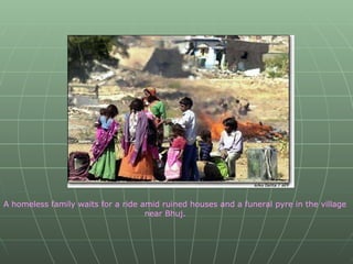 A homeless family waits for a ride amid ruined houses and a funeral pyre in the village  near Bhuj. 