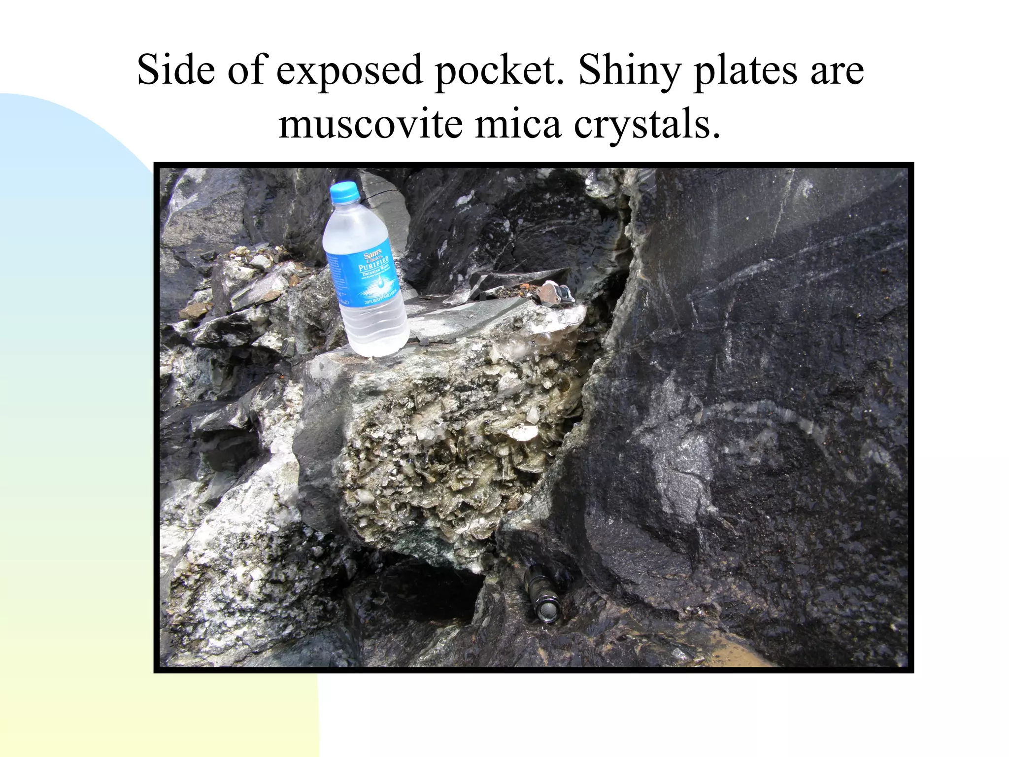 Side of exposed pocket. Shiny plates are muscovite mica crystals.