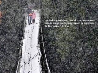 Un padre y su hija cruzando un puente roto
bajo la nieve en Dujiangyan en la provincia
de Sichuan en China
 