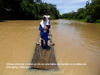 Chicas jóvenes cruzan un río en una balsa de bambú en la aldea de
Cilangkap, Indonesia
 