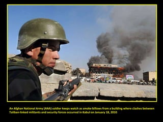 An Afghan National Army (ANA) soldier keeps watch as smoke billows from a building where clashes between  Taliban-linked militants and security forces occurred in Kabul on January 18, 2010 
