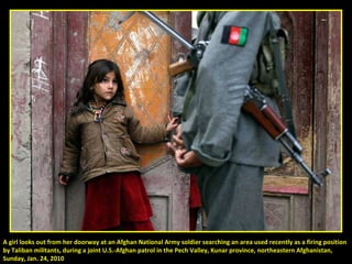 A girl looks out from her doorway at an Afghan National Army soldier searching an area used recently as a firing position  by Taliban militants, during a joint U.S.-Afghan patrol in the Pech Valley, Kunar province, northeastern Afghanistan,  Sunday, Jan. 24, 2010 