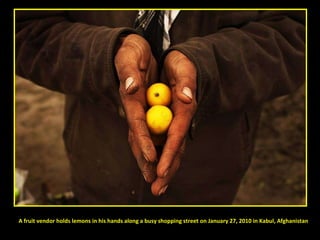 A fruit vendor holds lemons in his hands along a busy shopping street on January 27, 2010 in Kabul, Afghanistan 