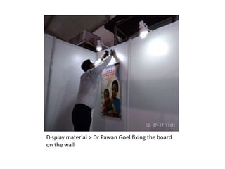 Display material > Dr Pawan Goel fixing the board
on the wall
 