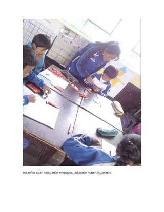 Los niños están trabajando en grupos, utilizando material concreto.
 