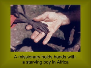 A missionary holds hands with
a starving boy in Africa
 