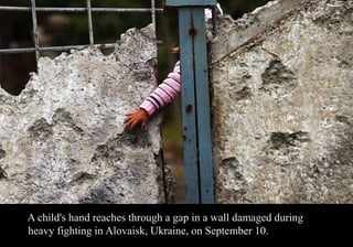 A child's hand reaches through a gap in a wall damaged during 
heavy fighting in Alovaisk, Ukraine, on September 10. 
 