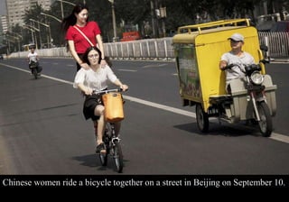 Chinese women ride a bicycle together on a street in Beijing on September 10. 
 
