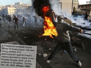 A Palestinian protester throws stones at Israeli troops, not seen, during clashes at a demonstration against Israel's military operation in Gaza, in the Shuafat refugee camp, on the outskirts of Jerusalem, Sunday, Dec. 28, 2008.  (Photo: CBS)   