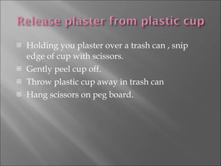 Holding you plaster over a trash can , snip edge of cup with scissors. Gently peel cup off. Throw plastic cup away in trash can Hang scissors on peg board. 