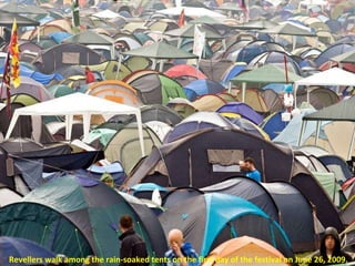 Revellers walk among the rain-soaked tents on the first day of the festival on June 26, 2009.  
