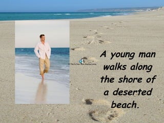 A young man walks along the shore of a deserted beach.  