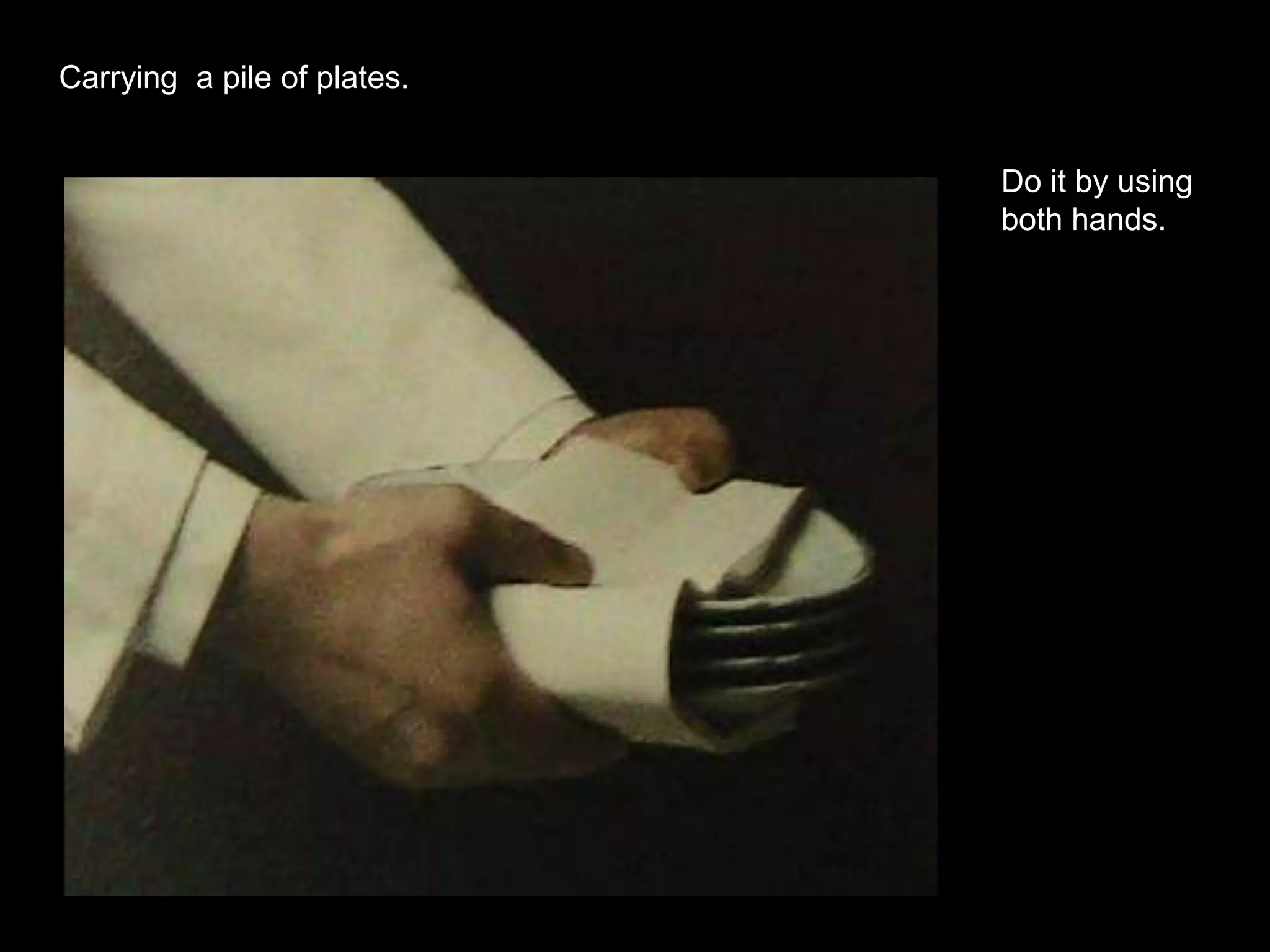 Carrying  a pile of plates.Do it by using both hands.