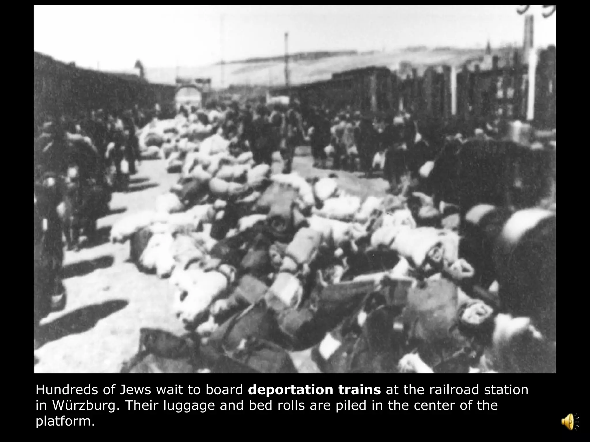 Hundreds of Jews wait to board  deportation   trains  at the railroad station in Würzburg. Their luggage and bed rolls are piled in the center of the platform.  