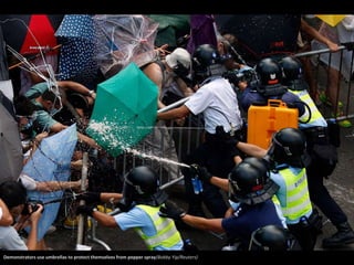 Demonstrators use umbrellas to protect themselves from pepper spray(Bobby Yip/Reuters) 
 
