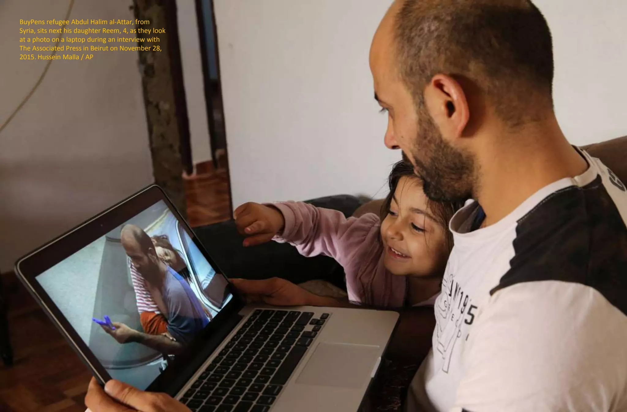 BuyPens refugee Abdul Halim al-Attar, from
Syria, sits next his daughter Reem, 4, as they look
at a photo on a laptop during an interview with
The Associated Press in Beirut on November 28,
2015. Hussein Malla / AP
 