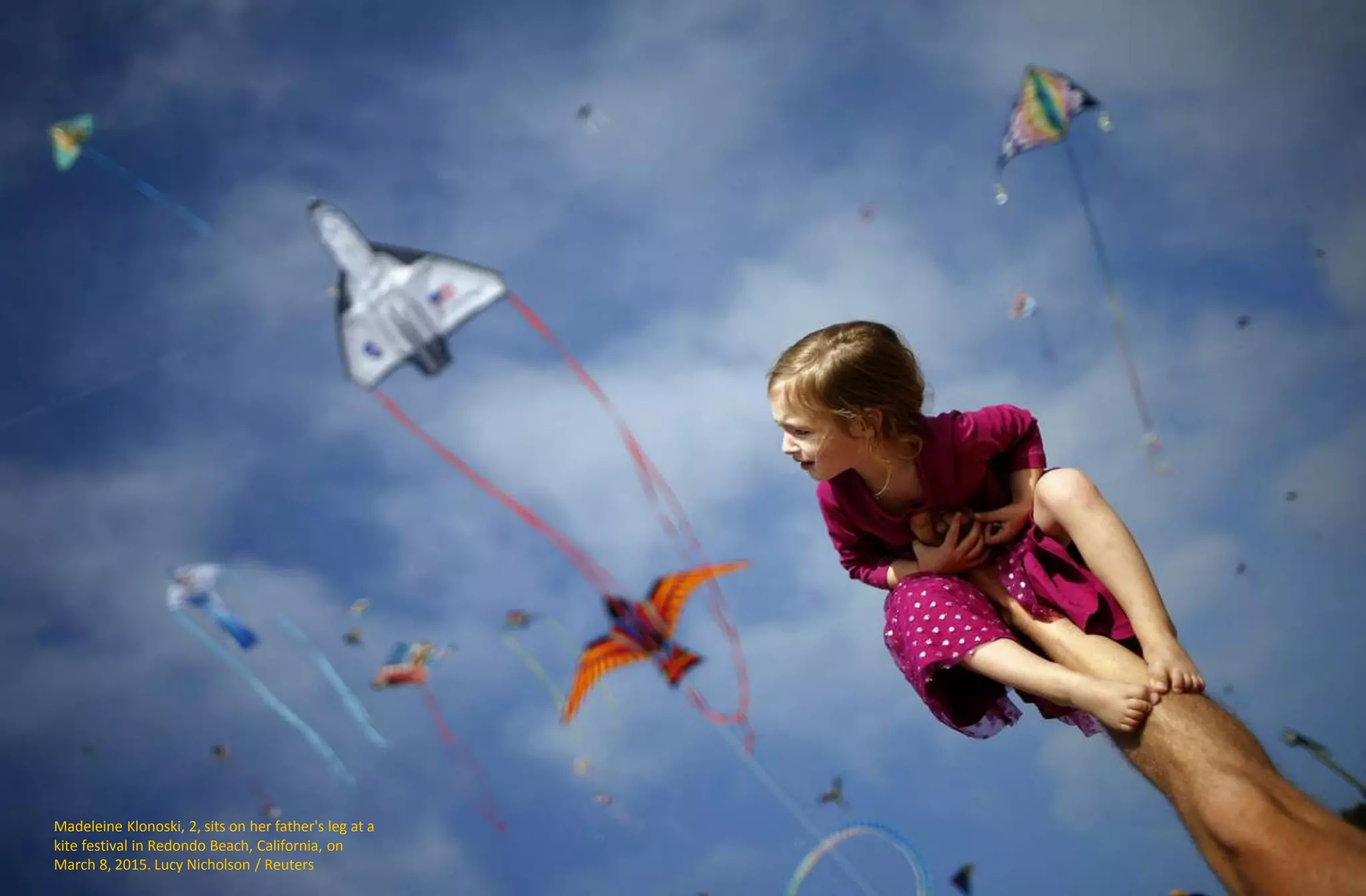 Madeleine Klonoski, 2, sits on her father's leg at a
kite festival in Redondo Beach, California, on
March 8, 2015. Lucy Nicholson / Reuters
 