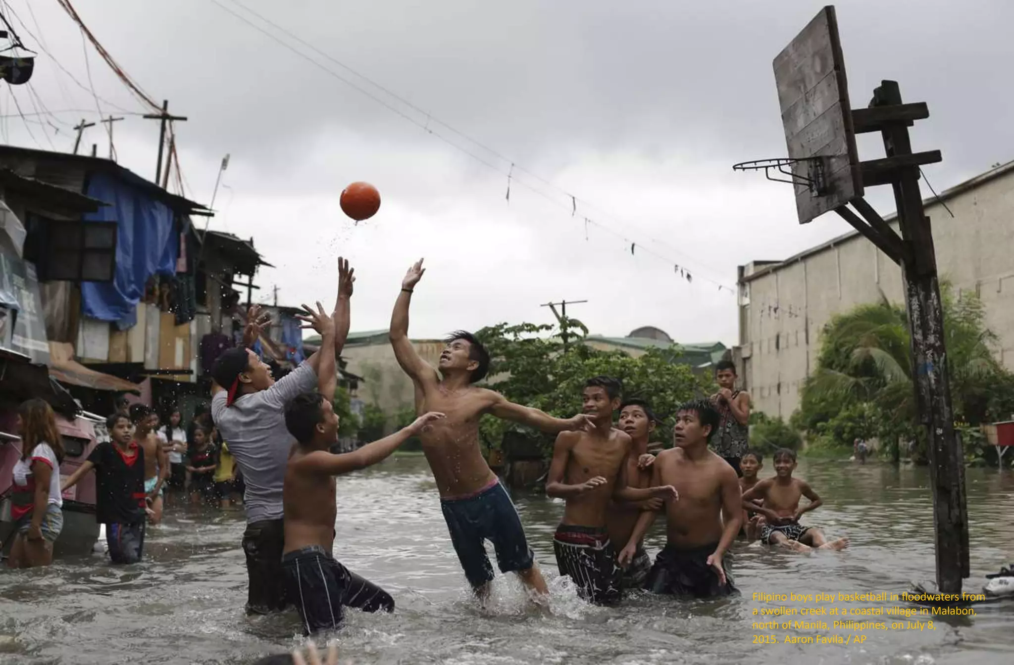 Filipino boys play basketball in floodwaters from
a swollen creek at a coastal village in Malabon,
north of Manila, Philippines, on July 8,
2015. Aaron Favila / AP
 