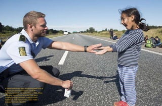 A Danish policeman plays a guessing game with a
migrant girl at the E45 freeway north of
Padborg, Denmark, on September 9, 2015. Many
migrants, mainly from Syria and Iraq, were
crossing through Denmark, trying to reach
Sweden to seek asylum there. Claus Fisker /
Scanpix Denmark / Reuters
 