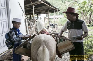42-year-old Ridwan Sururi prepares books
while a boy selects book from the mobile
library in Serang Village, Purbalingga,
Indonesia, on May 5, 2015. Putu Sayoga /
 