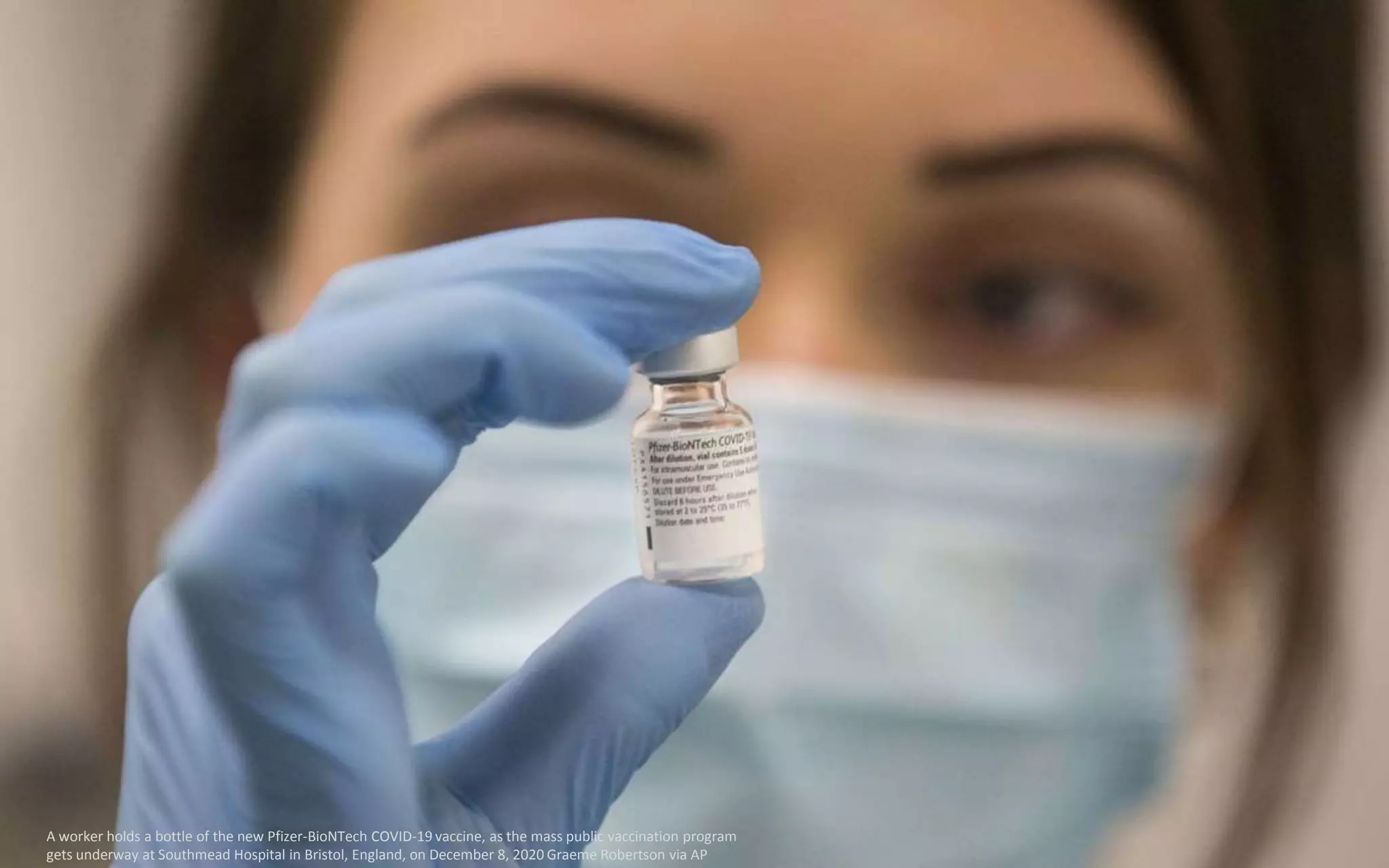 A worker holds a bottle of the new Pfizer-BioNTech COVID-19 vaccine, as the mass public vaccination program
gets underway at Southmead Hospital in Bristol, England, on December 8, 2020 Graeme Robertson via AP
 