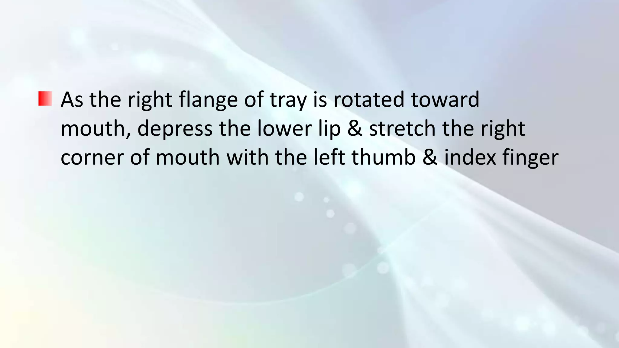 As the right flange of tray is rotated toward
mouth, depress the lower lip & stretch the right
corner of mouth with the left thumb & index finger
 