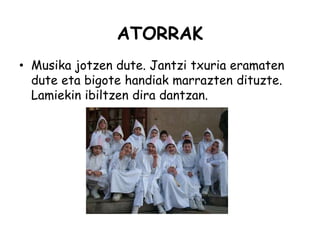 ATORRAK
• Musika jotzen dute. Jantzi txuria eramaten
dute eta bigote handiak marrazten dituzte.
Lamiekin ibiltzen dira dantzan.
 
