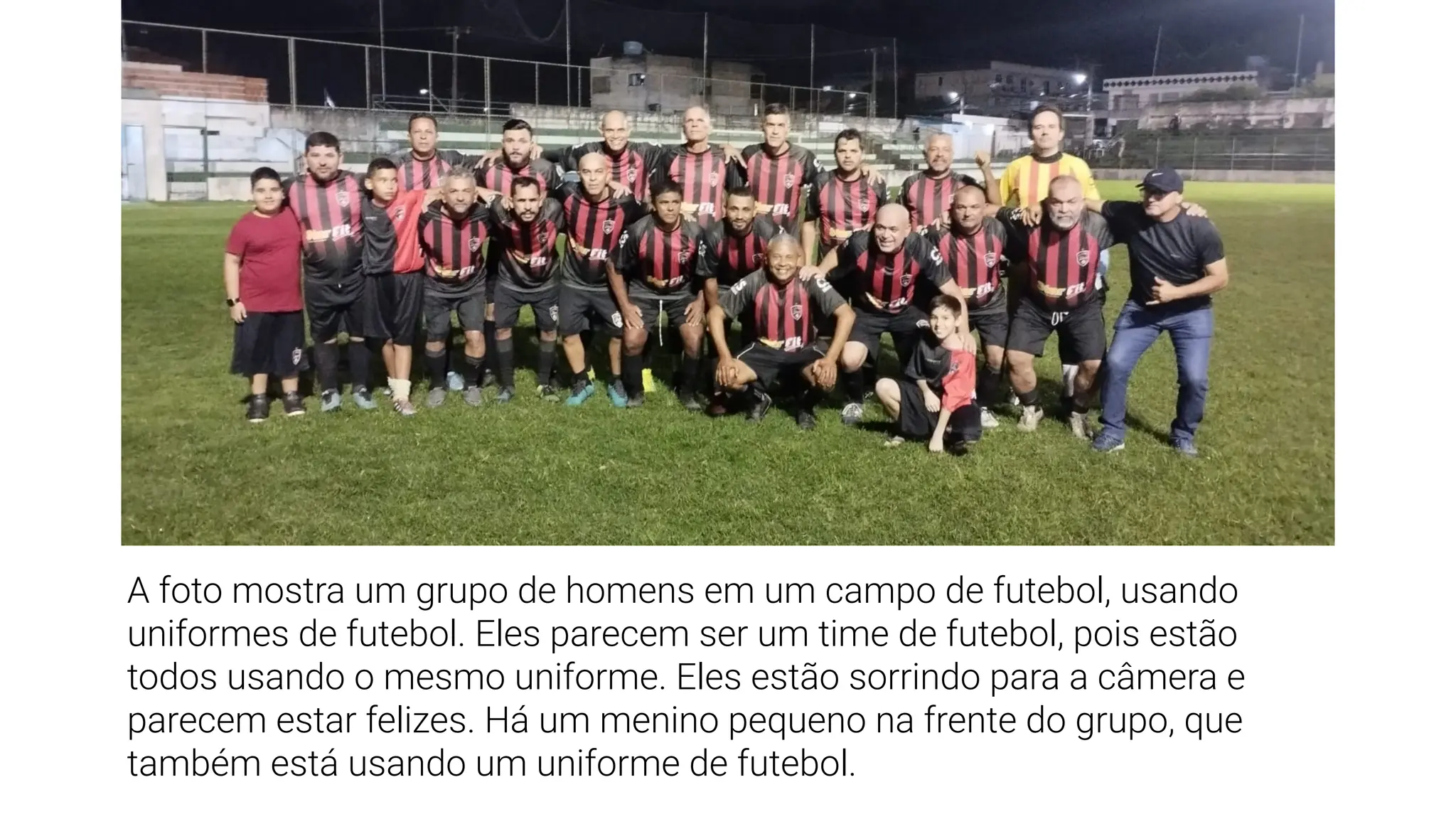 A foto mostra um grupo de homens em um campo de futebol, usando
uniformes de futebol. Eles parecem ser um time de futebol, pois estão
todos usando o mesmo uniforme. Eles estão sorrindo para a câmera e
parecem estar felizes. Há um menino pequeno na frente do grupo, que
também está usando um uniforme de futebol.
 