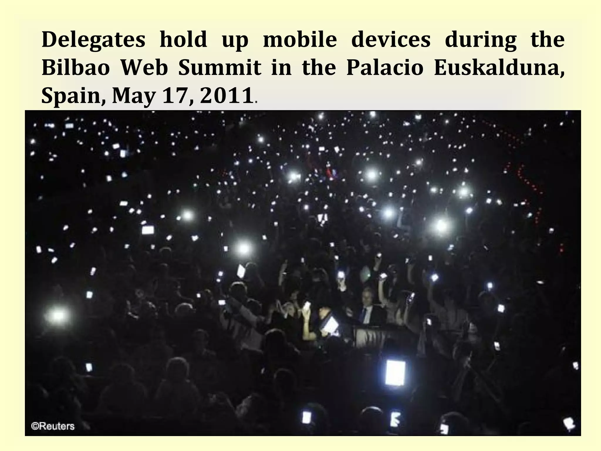 Delegates hold up mobile devices during the Bilbao Web Summit in the Palacio Euskalduna, Spain, May 17, 2011 . 