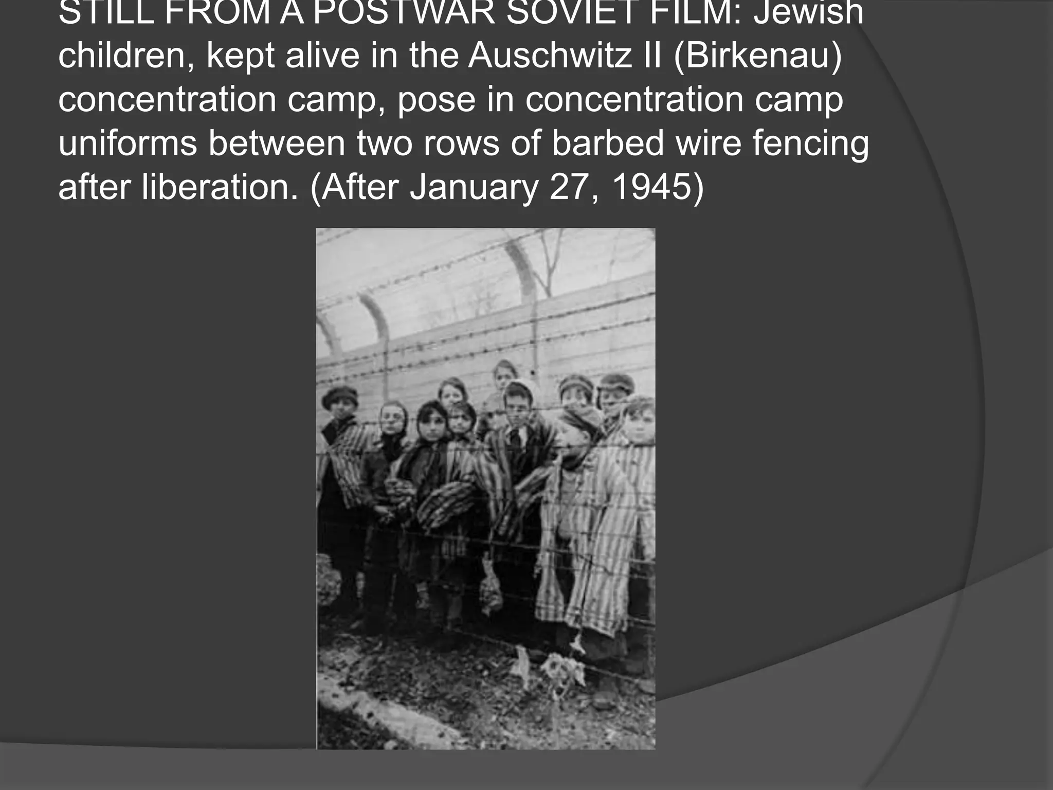 STILL FROM A POSTWAR SOVIET FILM: Jewish
children, kept alive in the Auschwitz II (Birkenau)
concentration camp, pose in concentration camp
uniforms between two rows of barbed wire fencing
after liberation. (After January 27, 1945)
 