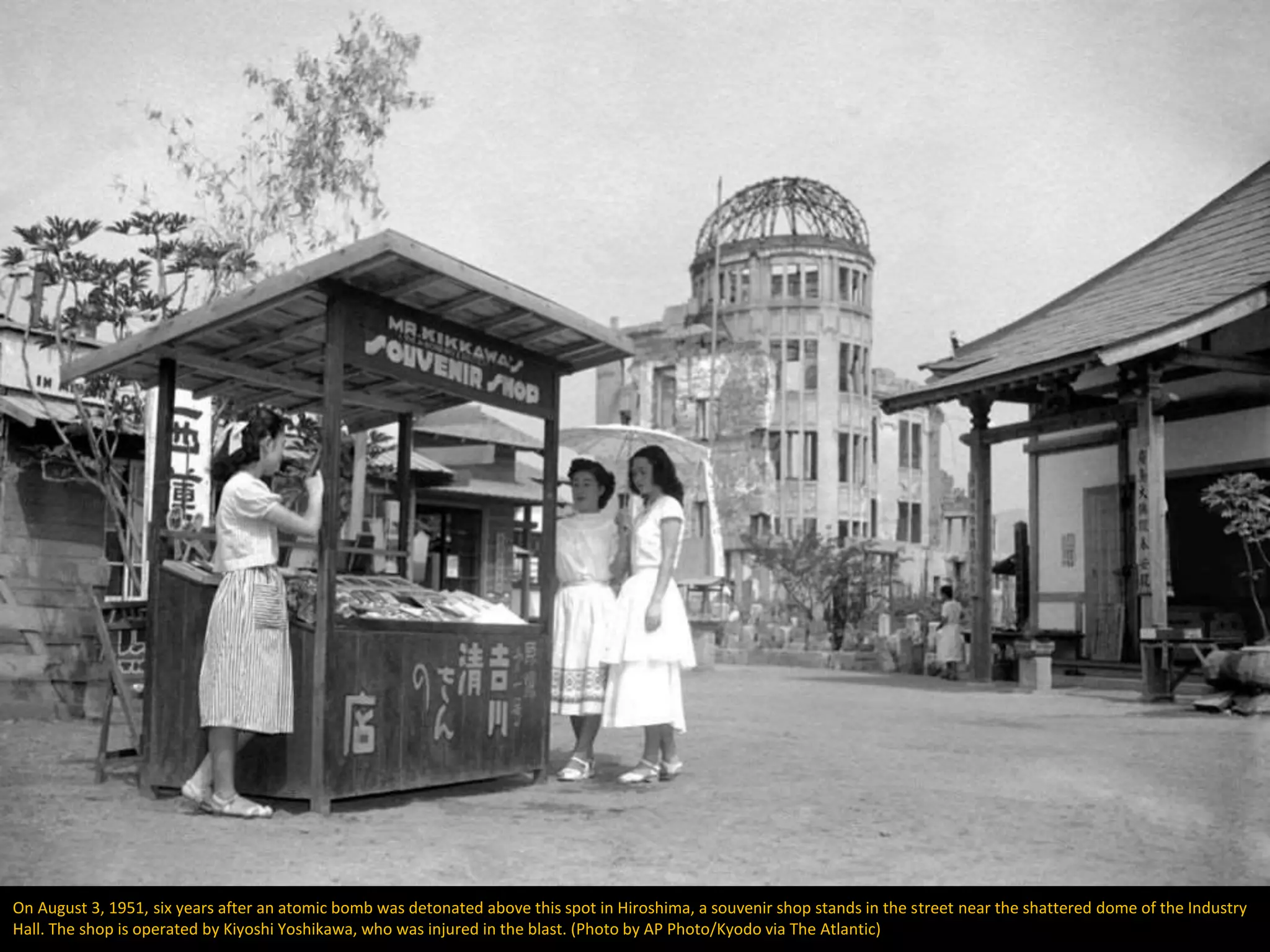 On August 3, 1951, six years after an atomic bomb was detonated above this spot in Hiroshima, a souvenir shop stands in the street near the shattered dome of the Industry
Hall. The shop is operated by Kiyoshi Yoshikawa, who was injured in the blast. (Photo by AP Photo/Kyodo via The Atlantic)
 
