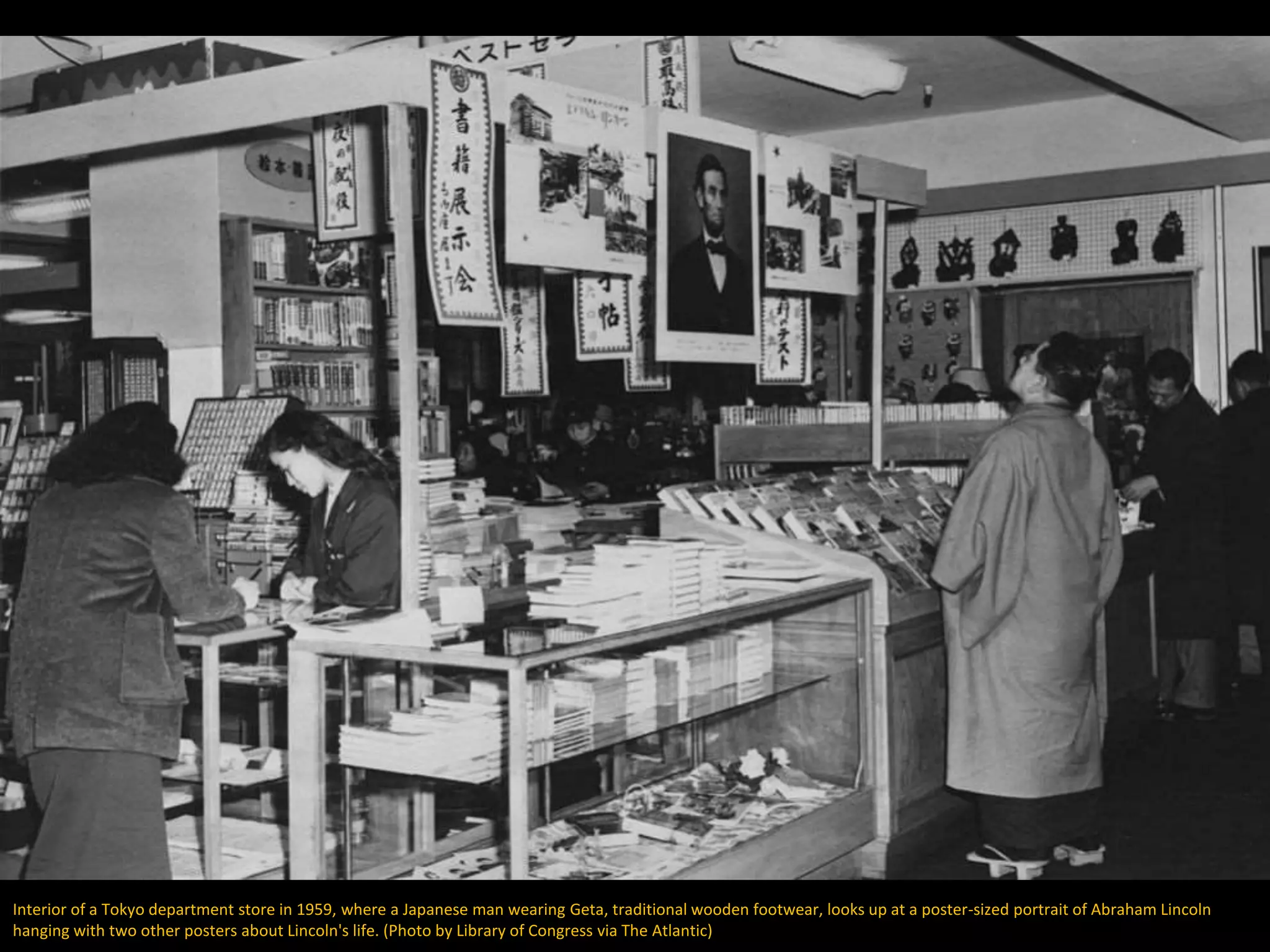 Interior of a Tokyo department store in 1959, where a Japanese man wearing Geta, traditional wooden footwear, looks up at a poster-sized portrait of Abraham Lincoln
hanging with two other posters about Lincoln's life. (Photo by Library of Congress via The Atlantic)
 