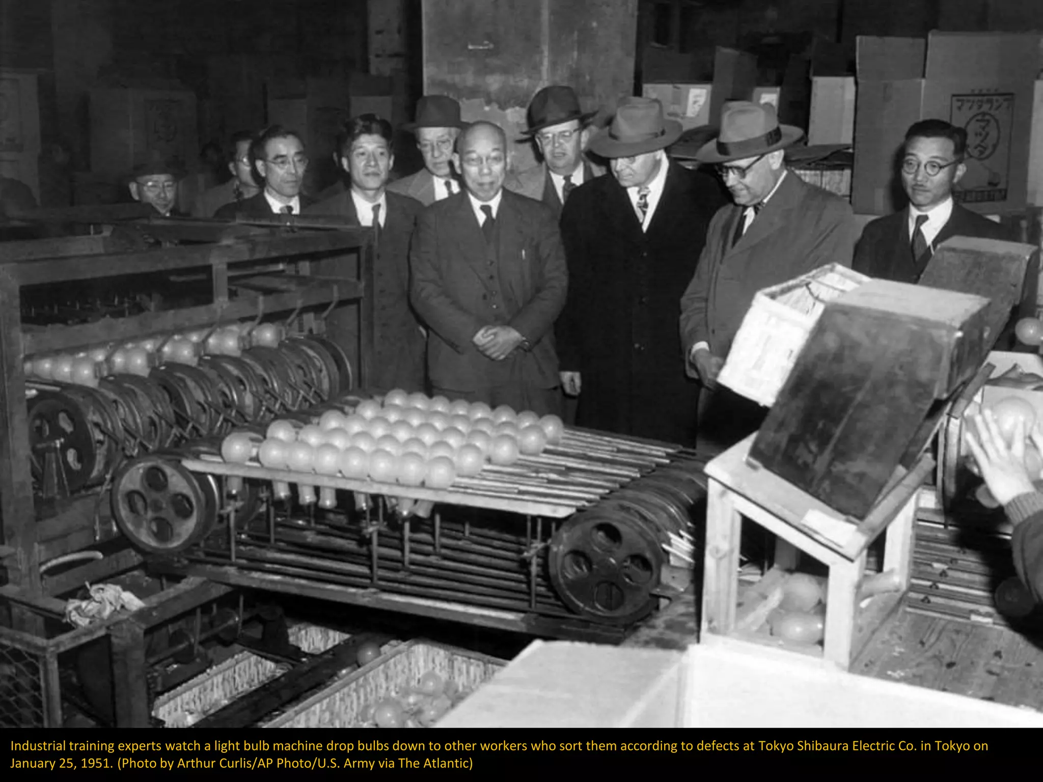 Industrial training experts watch a light bulb machine drop bulbs down to other workers who sort them according to defects at Tokyo Shibaura Electric Co. in Tokyo on
January 25, 1951. (Photo by Arthur Curlis/AP Photo/U.S. Army via The Atlantic)
 