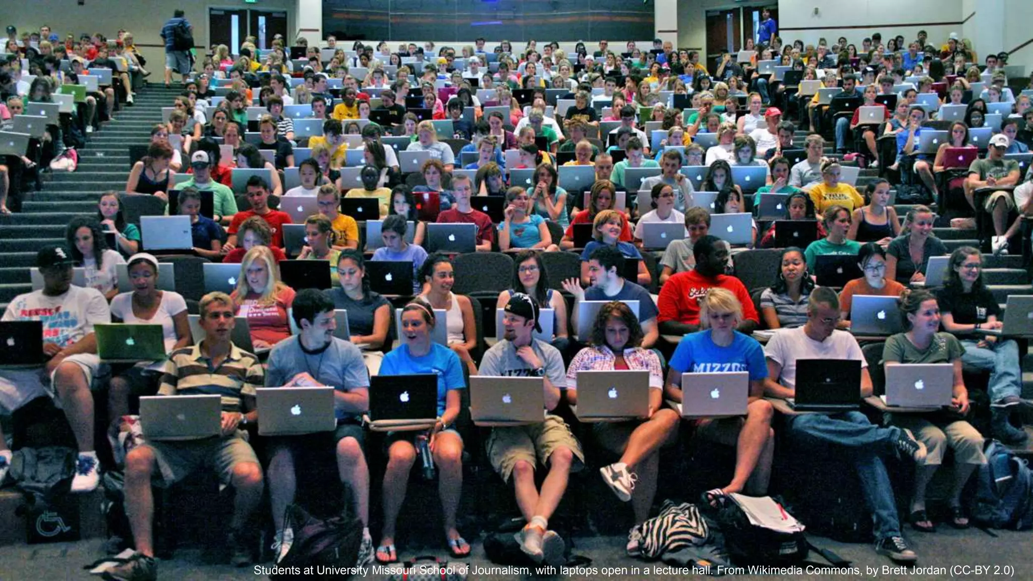 Students at University Missouri School of Journalism, with laptops open in a lecture hall. From Wikimedia Commons, by Brett Jordan (CC-BY 2.0)
 