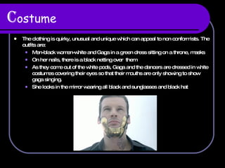 C ostume The clothing is  quirky, unusual and unique which can appeal to non conformists. The outfits are:  Men-black women-white and Gaga in a green dress sitting on a throne, masks On her nails, there is a black netting over  them As they come out of the white pods, Gaga and the dancers are dressed in white costumes covering their eyes so that their mouths are only showing to show gaga singing. She looks in the mirror wearing all black and sunglasses and black hat 
