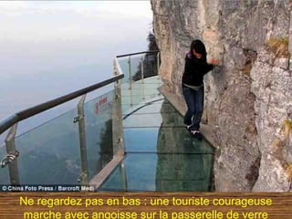Ne regardez pas en bas : une touriste courageuse
marche avec angoisse sur la passerelle de verre
 