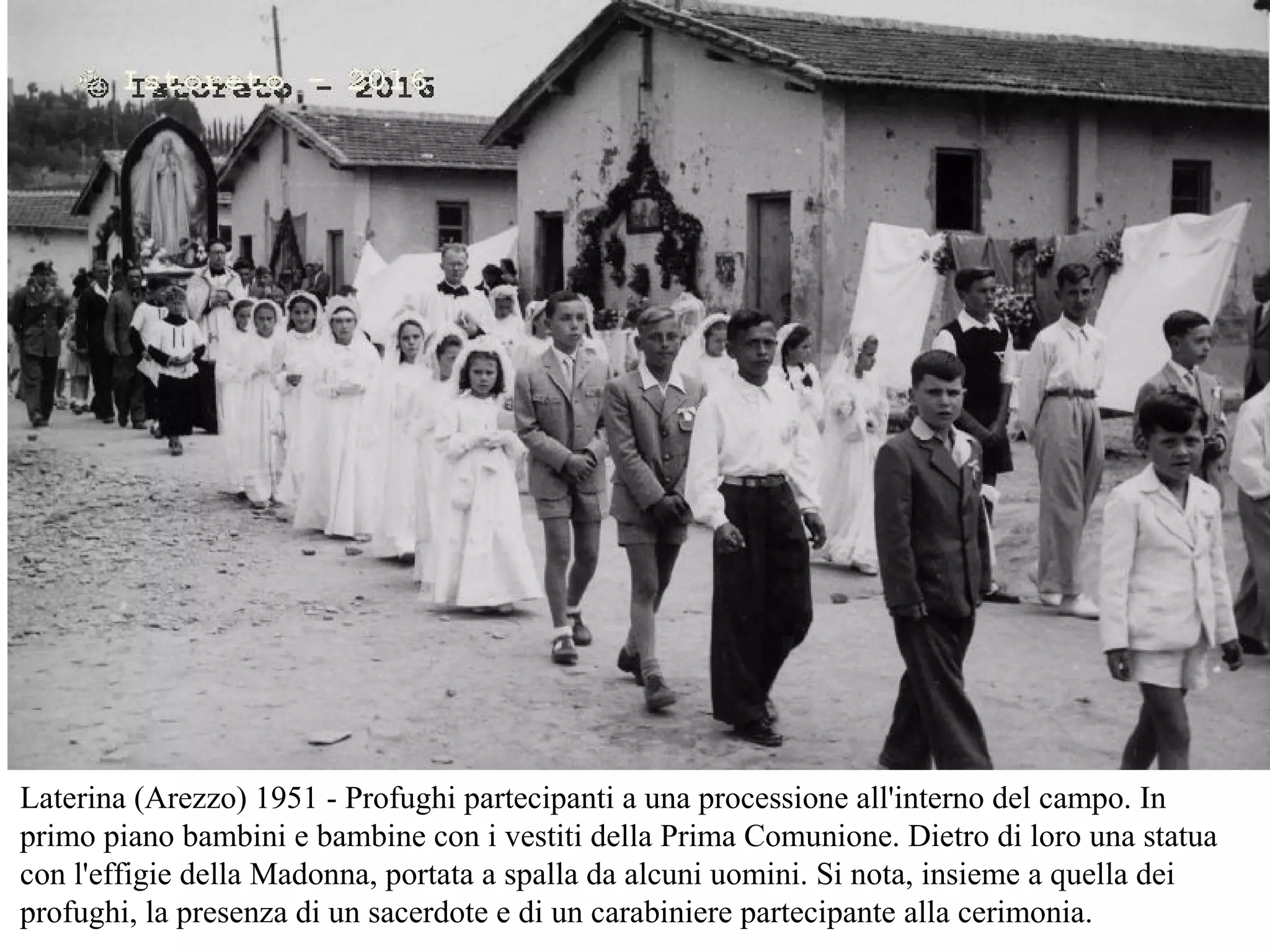 Laterina (Arezzo) 1951 - Profughi partecipanti a una processione all'interno del campo. In
primo piano bambini e bambine con i vestiti della Prima Comunione. Dietro di loro una statua
con l'effigie della Madonna, portata a spalla da alcuni uomini. Si nota, insieme a quella dei
profughi, la presenza di un sacerdote e di un carabiniere partecipante alla cerimonia.
 
