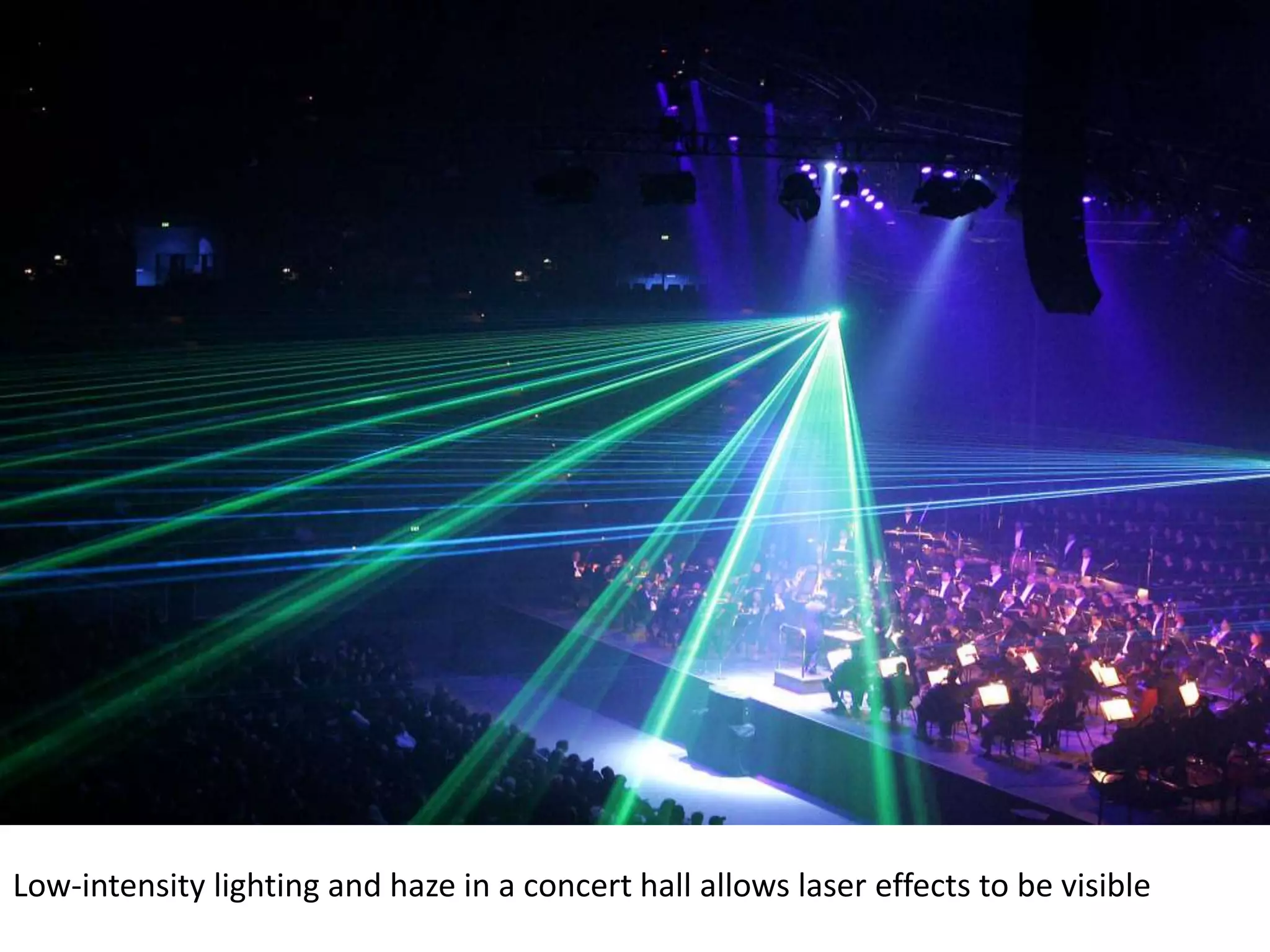 Low-intensity lighting and haze in a concert hall allows laser effects to be visible
 