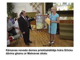 Kārsavas novada domes priekšsēdētāja Ināra Silicka
dāvina gleznu ar Malnavas skatu
 