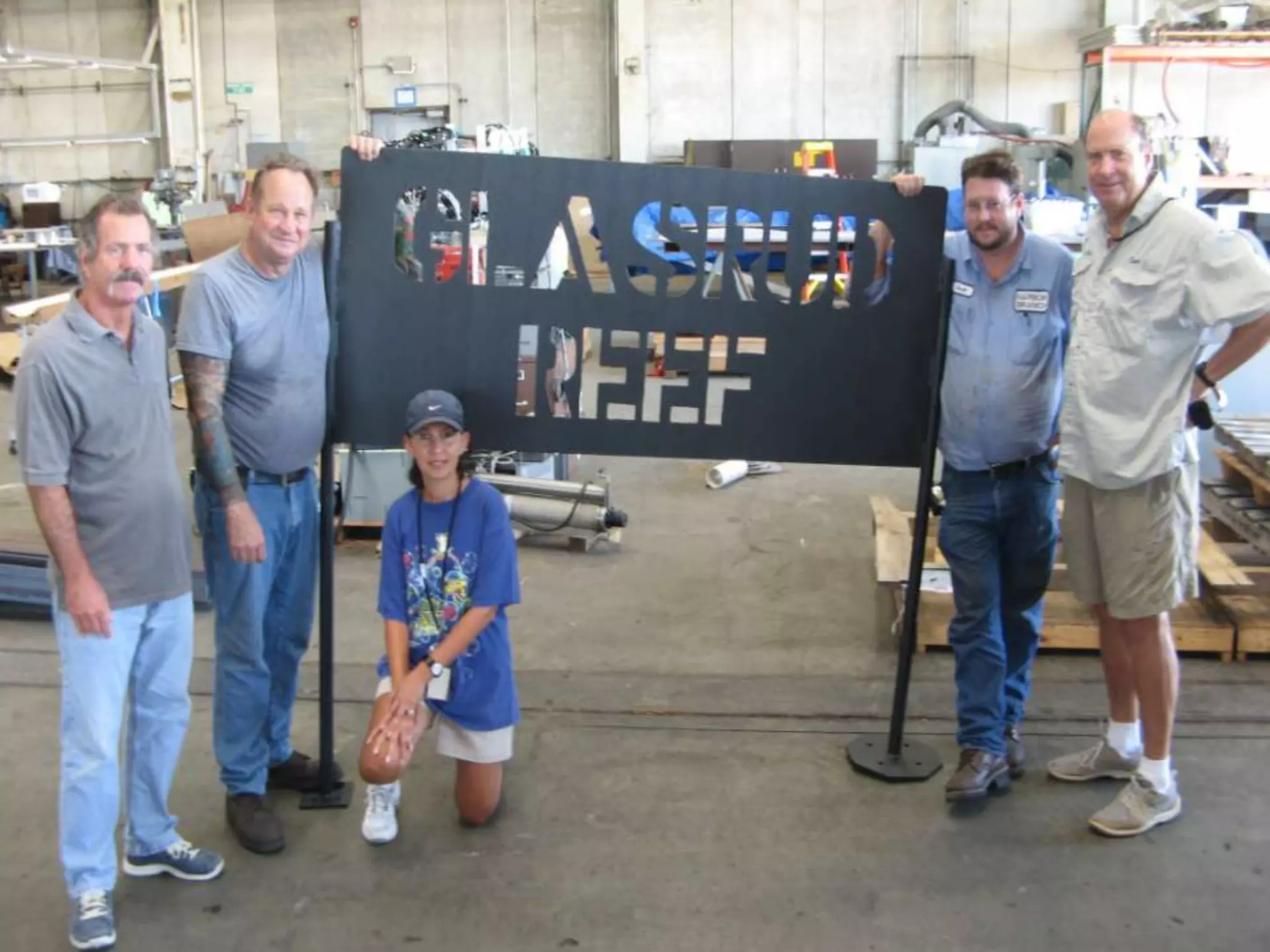 ON THE FAR LEFT IS GEOFF BEISER THE ENGINEERING MANAGER FOR HARBOR BRANCH WHO ORGANIZES THE WORK AND THE DONATION TO OUR FUND.  HE  GREW UP IN THE BAHAMAS WHILE I WAS THERE FOR 14 YEARS AND I KNEW HIS FATHER WELL.  WE HAVE WORKED TOGETHER ON EACH OF THE 11 SIGNS THAT THEY HAVE DONE FOR US.  THE YOUNG LADY IS THE DRAFTSPERSON WHO WORKS ON OUR SIGNS .  THE OTHER 2 GUYS I DON'T HAVE NAMES FOR, BUT THEY ARE THE WELDER AND PAINTER. FOR HARBOR BRANCH.  