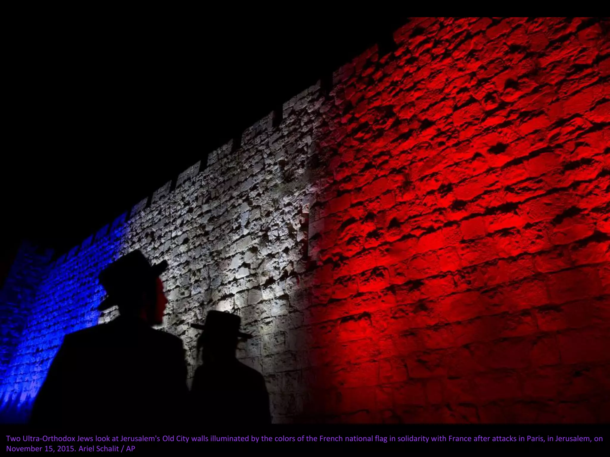 Two Ultra-Orthodox Jews look at Jerusalem's Old City walls illuminated by the colors of the French national flag in solidarity with France after attacks in Paris, in Jerusalem, on
November 15, 2015. Ariel Schalit / AP
 