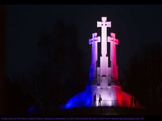 People walk near the Three Crosses in Vilnius, Lithuania, on November 15, 2015, illuminated by the colors of the French national flag. Mindaugas Kulbis / AP
 