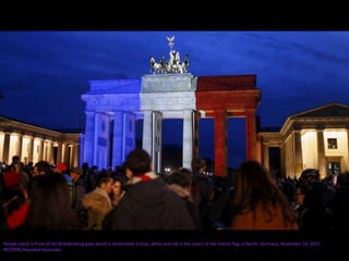 People stand in front of the Brandenburg gate which is illuminated in blue, white and red in the colors of the French flag, in Berlin, Germany, November 14, 2015.
REUTERS/Hannibal Hanschke
 