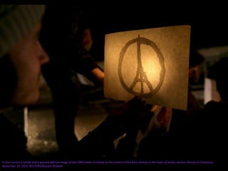 A man carries a candle and a placard with an image of the Eiffel tower in tribute to the victims of the Paris attacks in the town of Duma, eastern Ghouta in Damascus
November 14, 2015. REUTERS/Bassam Khabieh
 