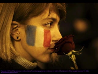 A woman with French flag painted on her face, holds a flower during a gathering in tribute to the victims of Paris attacks in Tbilisi, Georgia, November 14, 2015.
REUTERS/David Mdzinarishvili
 