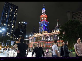 People walk past the Sydney Town Hall as it is lit in red, white and blue, the colors of the French flag, in Sydney, Australia, on on November 14, 2015. William West / AFP /
Getty
 